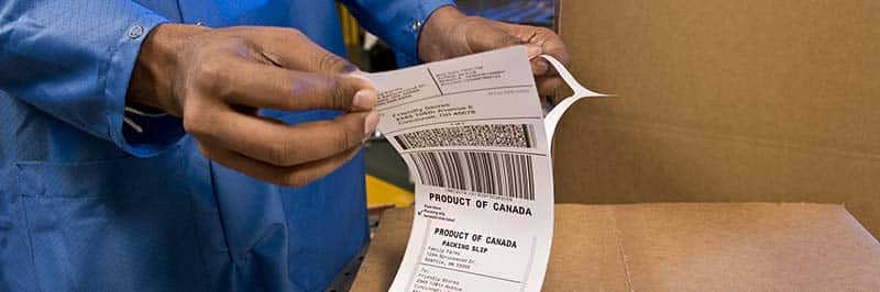 A Person Removing A Barcode Labels Backing
